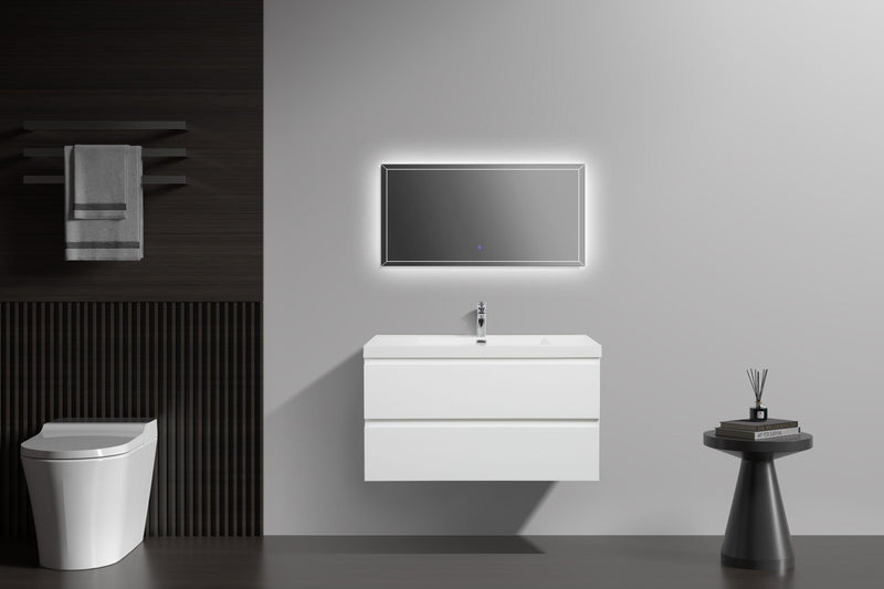 Modern bathroom with white floating vanity, LED mirror, toilet, towel rack, and decorative side table.
