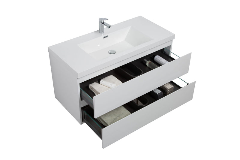 White bathroom vanity with open drawers filled with towels and toiletries.