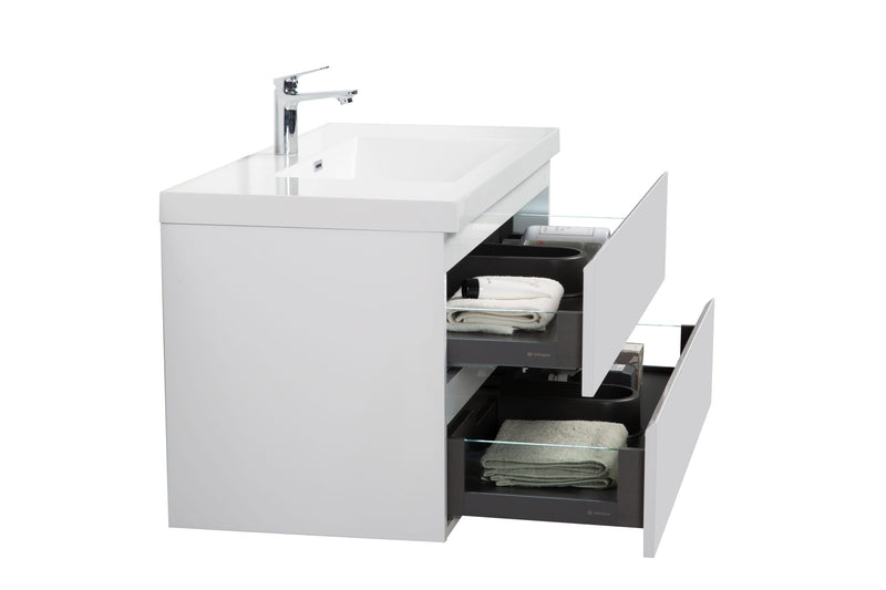 White bathroom vanity with two open drawers, revealing towels and bathroom accessories.