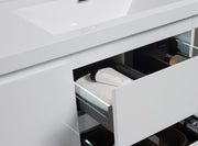 White bathroom vanity with open drawers and toiletries.