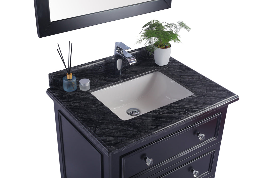 Bathroom vanity with black marble countertop, white sink, chrome faucet, potted plant, and cosmetic accessories.