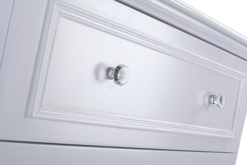 Close-up of a white dresser drawer with crystal knobs.