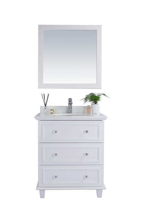 White bathroom vanity with mirror, drawers, and decor.