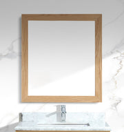Bathroom vanity with wooden-framed mirror and marble countertop.
