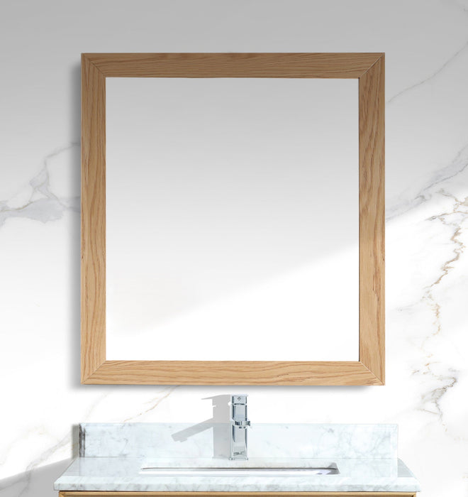 Bathroom vanity with wooden-framed mirror and marble countertop.
