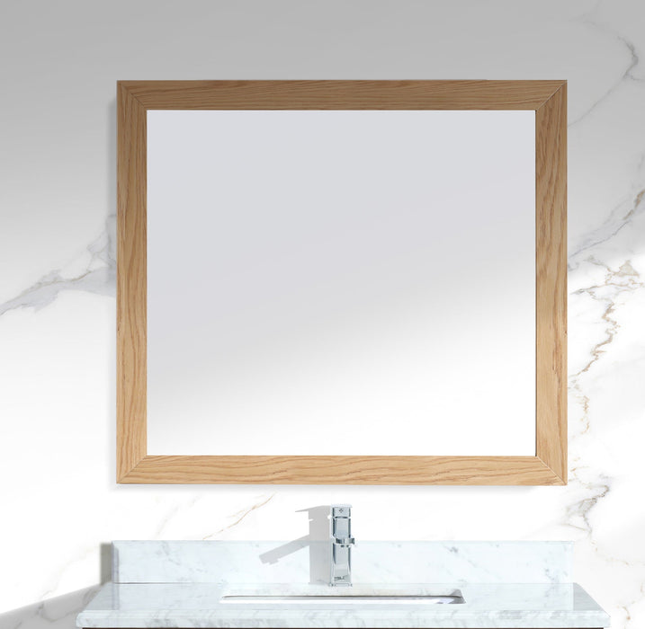 Square wooden-framed mirror over marble bathroom sink with chrome faucet.

