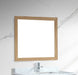 Square, wood-framed mirror above a bathroom vanity with marble countertop and chrome faucet.