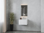 Bathroom vanity with mirror, gray marble walls, and potted plant.
