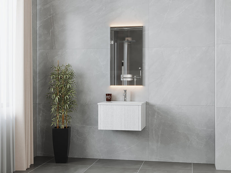 Bathroom vanity with mirror, gray marble walls, and potted plant.
