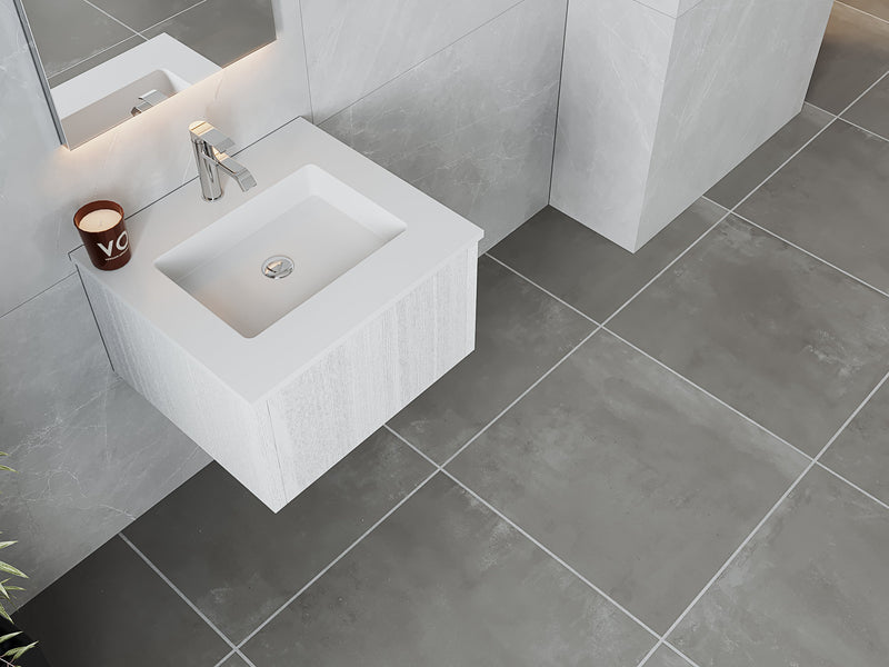 Modern bathroom vanity with white sink, chrome faucet, and gray tile.
