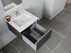 Modern bathroom vanity with a white countertop, sink, chrome faucet, open drawer, and gray tile flooring.
