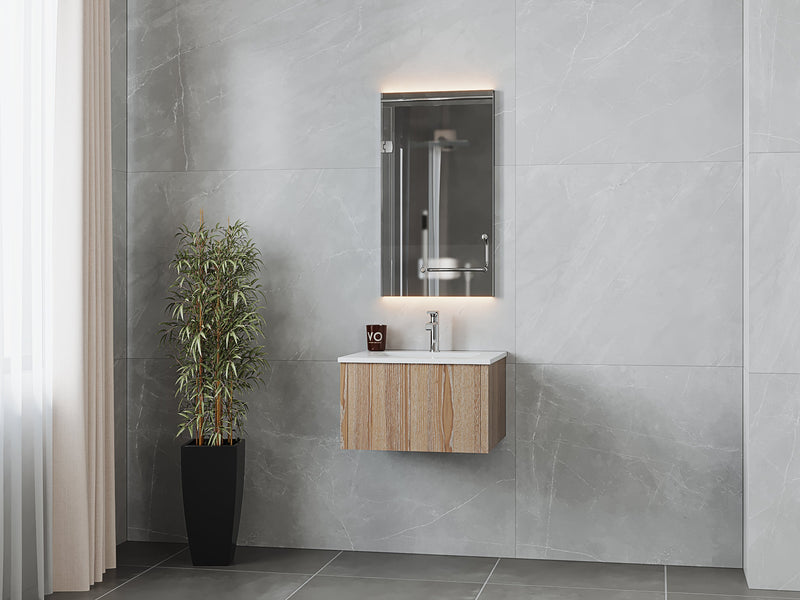 Bathroom vanity with mirrored medicine cabinet, gray tile, and tall plant.
