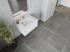 Modern bathroom with gray tile floor and walls, white sink, and potted plant.