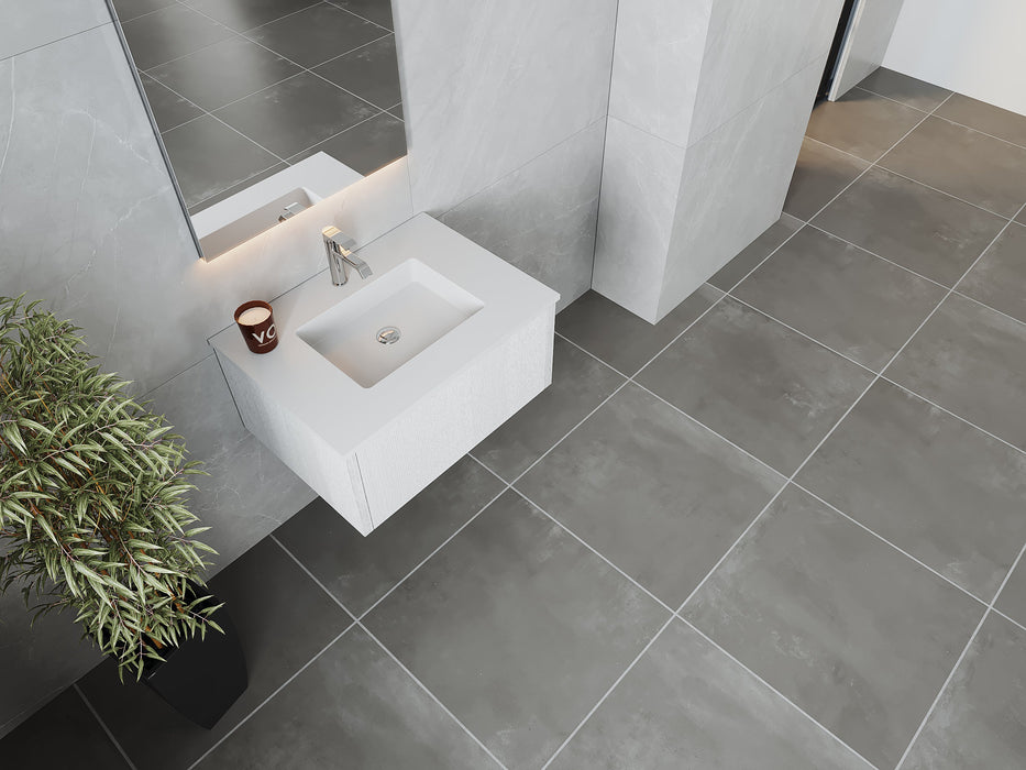 Modern bathroom with gray tile floor and walls, white sink, and potted plant.