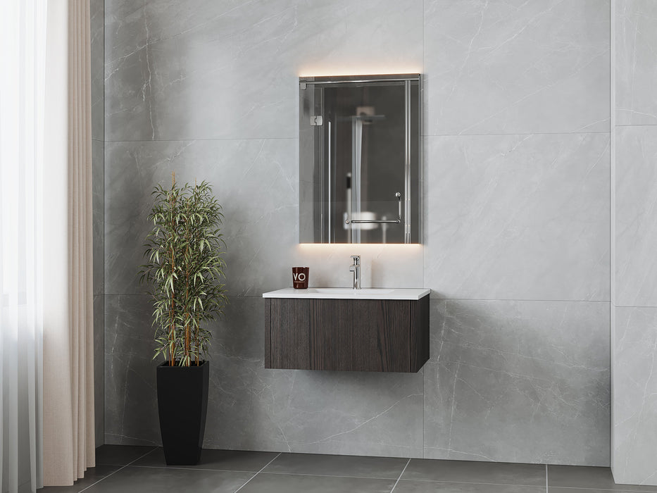 Bathroom with gray marble walls, floating dark-wood vanity, lighted mirror, and potted plant.
