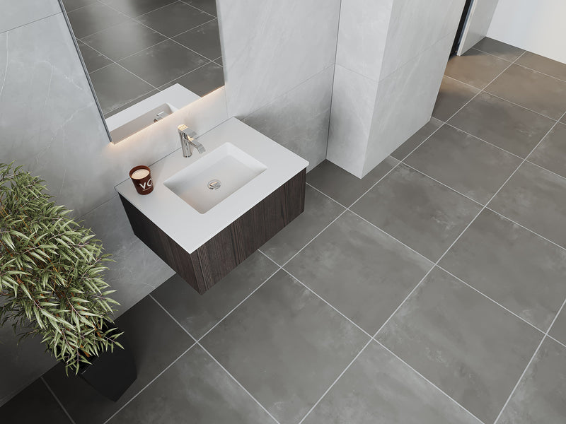 Bathroom with gray tile, white sink, and wooden vanity.