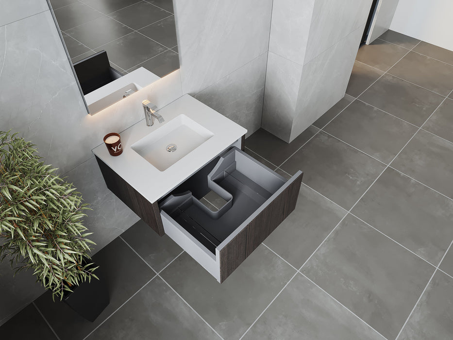 Bathroom vanity with open drawer, white sink, and faux potted plant.

