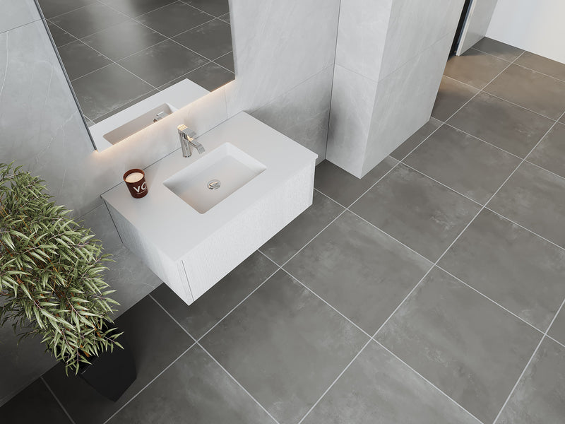 Bathroom with gray tile flooring, white sink and vanity, and potted plant.