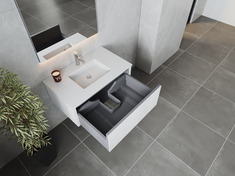Bathroom vanity with open drawer, gray tile flooring, and potted plant.