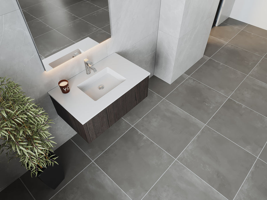 Modern bathroom with gray tile floor, floating vanity, and plant.