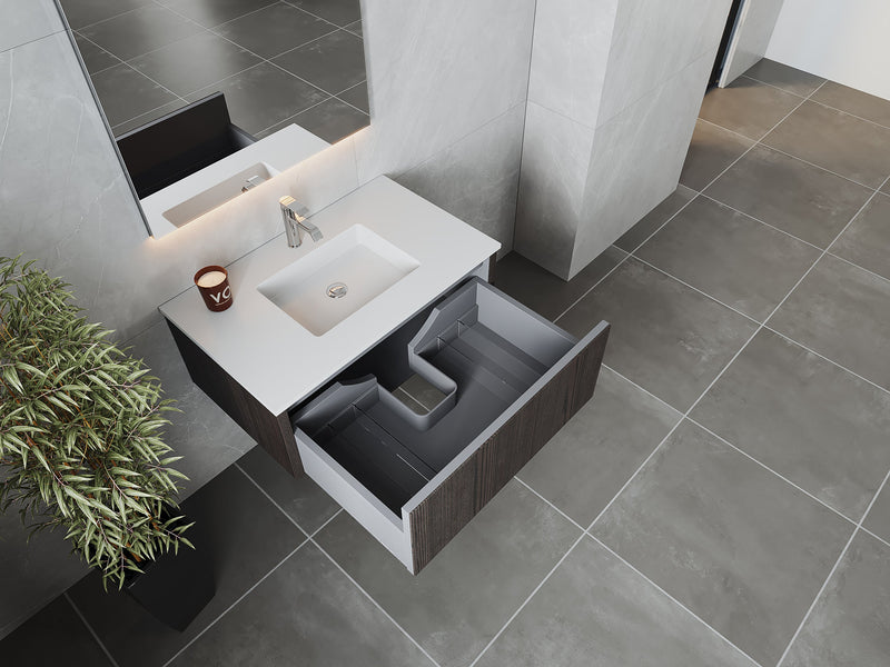 Bathroom vanity with white countertop, open drawer, and potted plant.