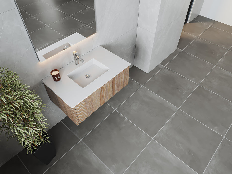 Modern bathroom with gray tile, wood vanity, and decorative plant.
