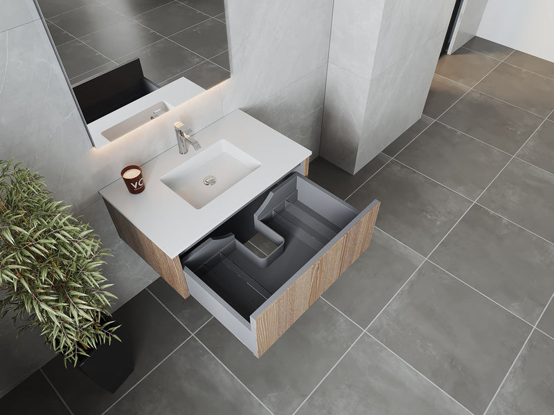 Bathroom vanity with open drawer, gray tiled floor, potted plant.