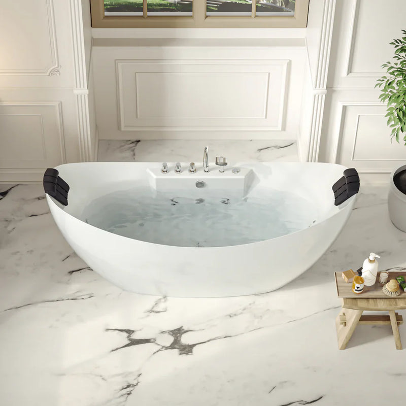 Modern white freestanding bathtub with water, set on marble floor with window and green plant, featuring sleek design and bath accessories on wooden side table.