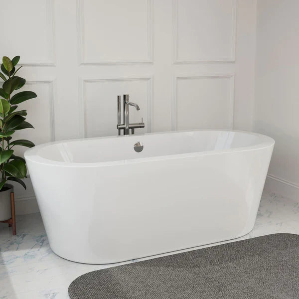 Modern white freestanding bathtub with sleek chrome faucet, placed on marble tile floor next to a potted green plant.