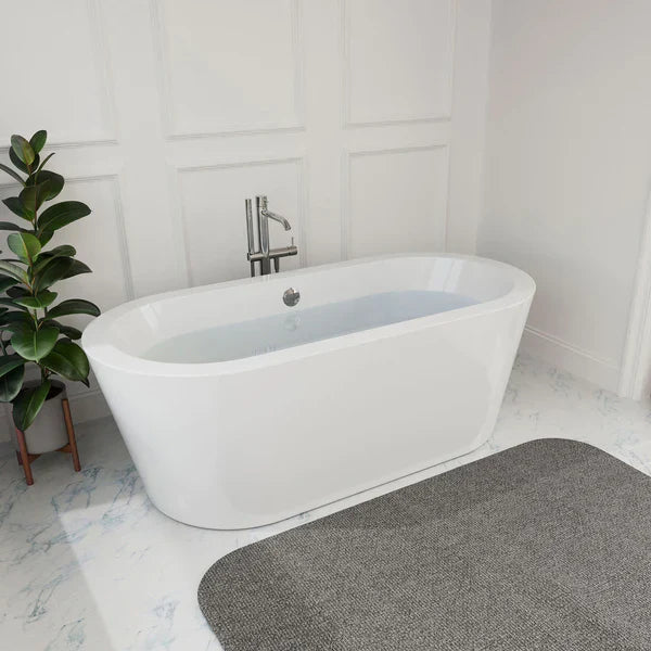 Modern white freestanding bathtub with sleek chrome faucet, placed on marble floor next to a green potted plant and gray bath mat.