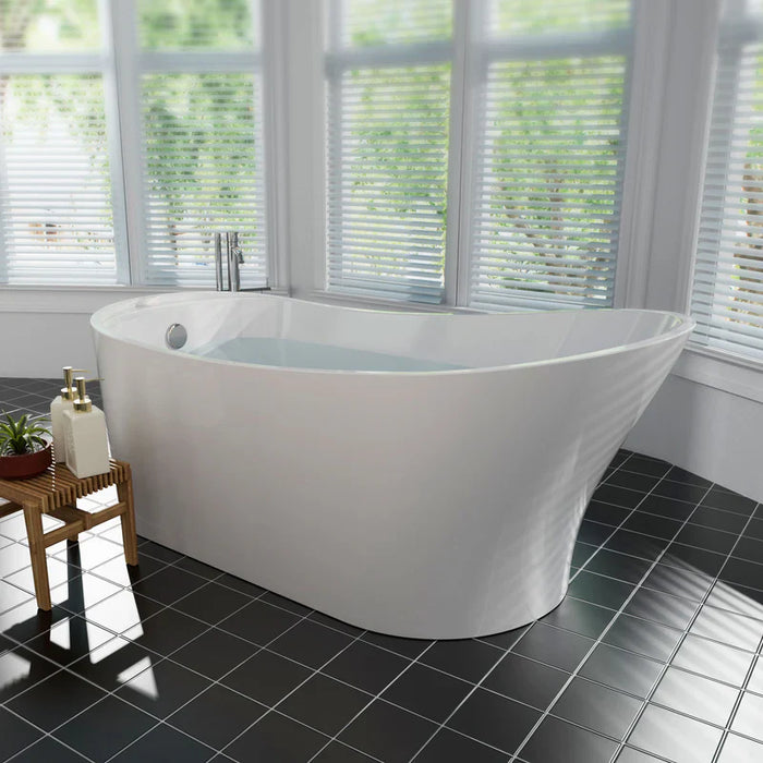 Modern white freestanding bathtub with curved design, placed on dark tile floor beside windows with white blinds and wooden bath accessories.