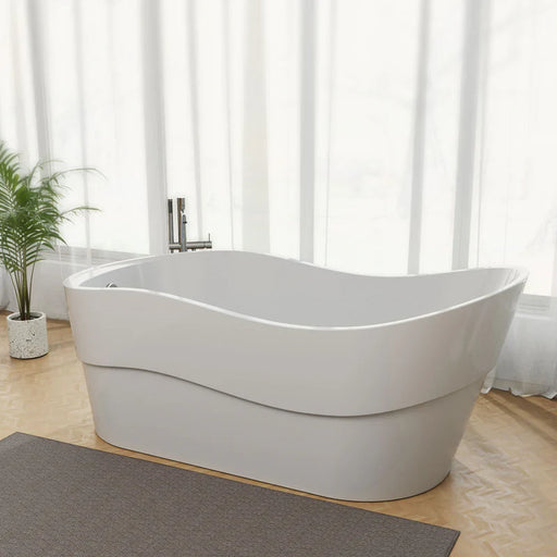 Modern white freestanding bathtub with curved design, placed on wooden floor with gray mat and green potted plant, soft curtains in background