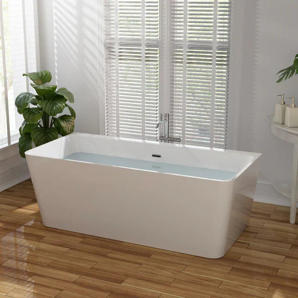 Modern white freestanding bathtub with water, placed on wooden floor near white shuttered window and green leafy plant.