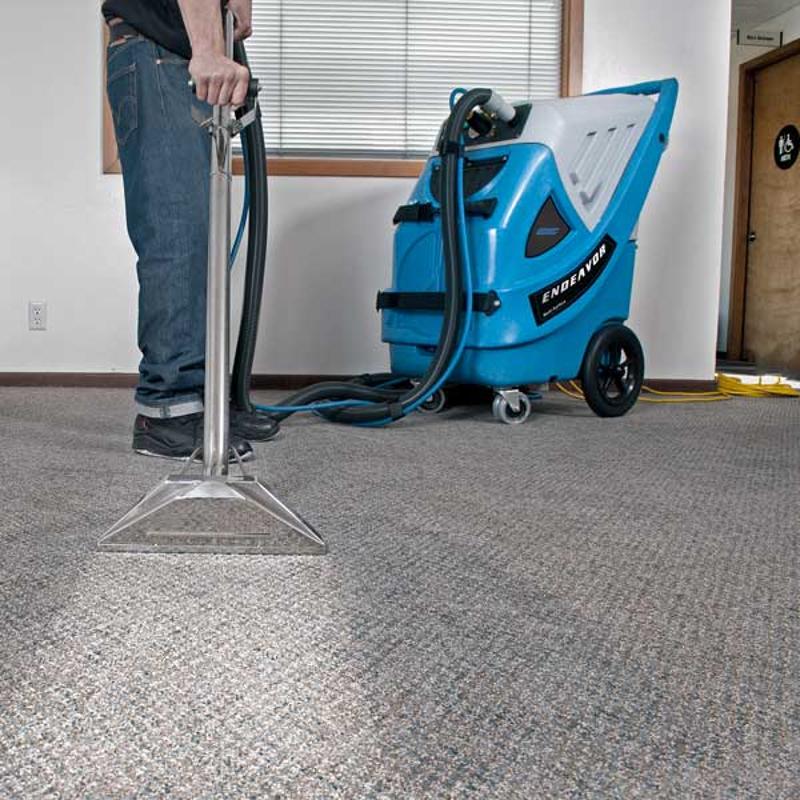 EDIC Endeavor Multi Surface Cleaning System person cleaning carpet with attachments.