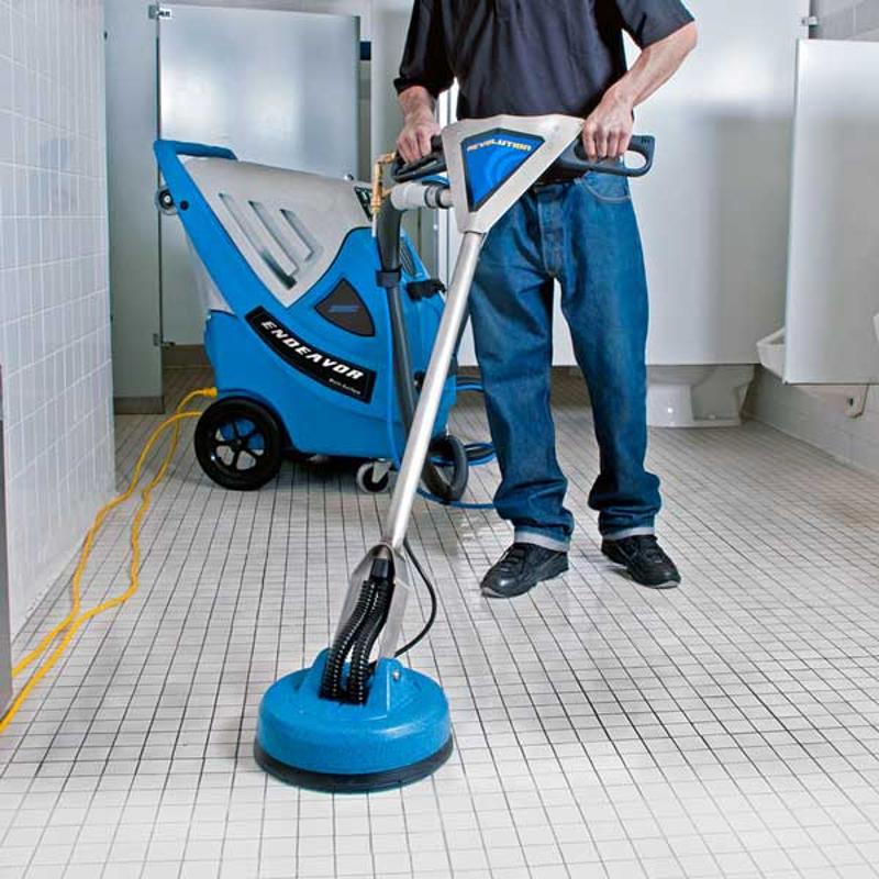 EDIC Endeavor Multi Surface Cleaning System person cleaning tile floor in bathroom.