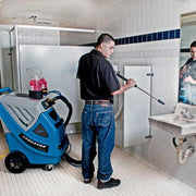 EDIC Endeavor Multi Surface Cleaning System person using lance to clean restroom wall.