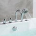 Chrome bath faucet and handheld shower head with water flowing, mounted on a white tub against a gray marble wall.