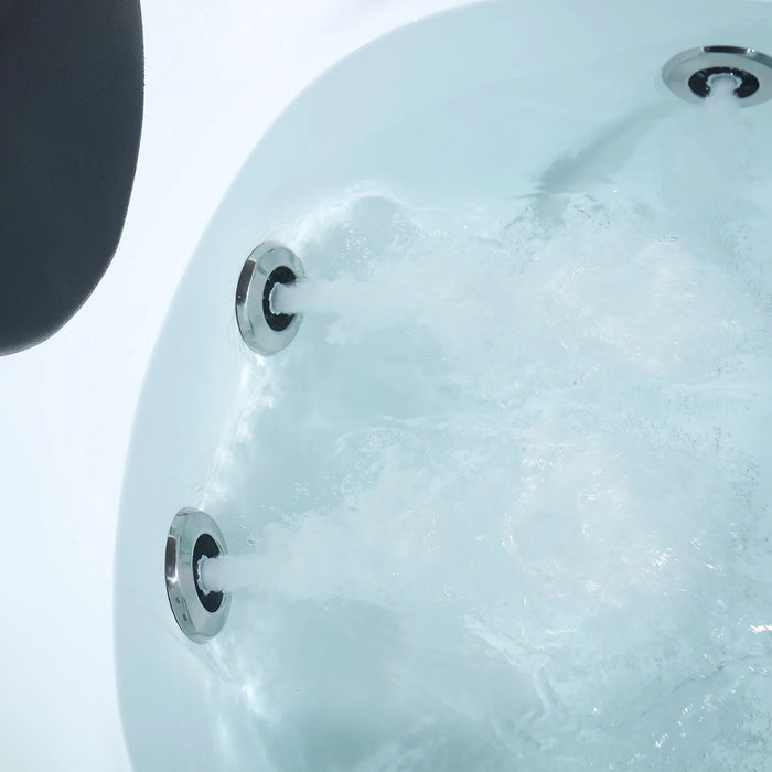 Bubbling hot tub water with three metallic circular jets against a white background