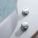 Two chrome water control knobs with textured surfaces on a white and pale green surface.