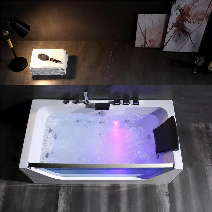 Modern bathtub with purple and blue lighting, bubbling water, and desk lamp illuminating white towel and hairbrush nearby