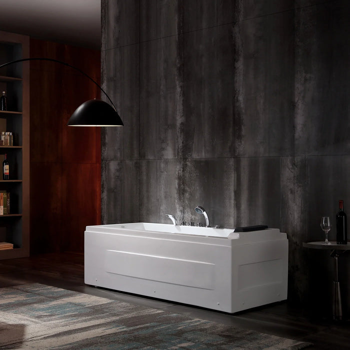 White bathtub against dark concrete wall, with black pendant lamp and wine bottle nearby, creating a moody, minimalist bathroom setting.