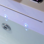 Close-up of a white device with blue-lit circular indicators and a reflective surface showing a blurred round element.