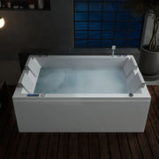 Modern white bathtub filled with steamy water, positioned near a blue-tinted window with wooden floor and potted plant in background.