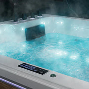 Steaming hot tub with turquoise water, bubbling jets, and digital control panel illuminated in soft blue light.