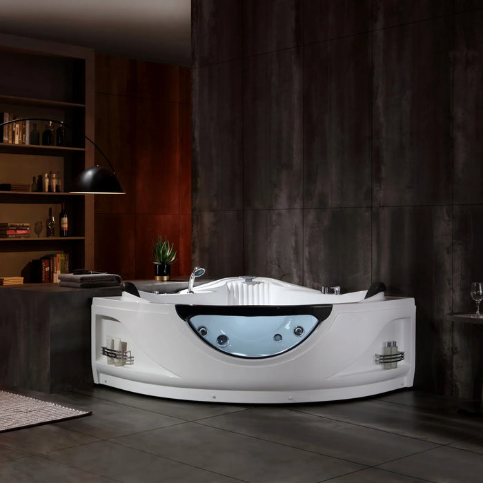Modern white whirlpool bathtub with curved design and blue glass accent, placed in a dark, industrial-style bathroom with bookshelves and mood lighting.