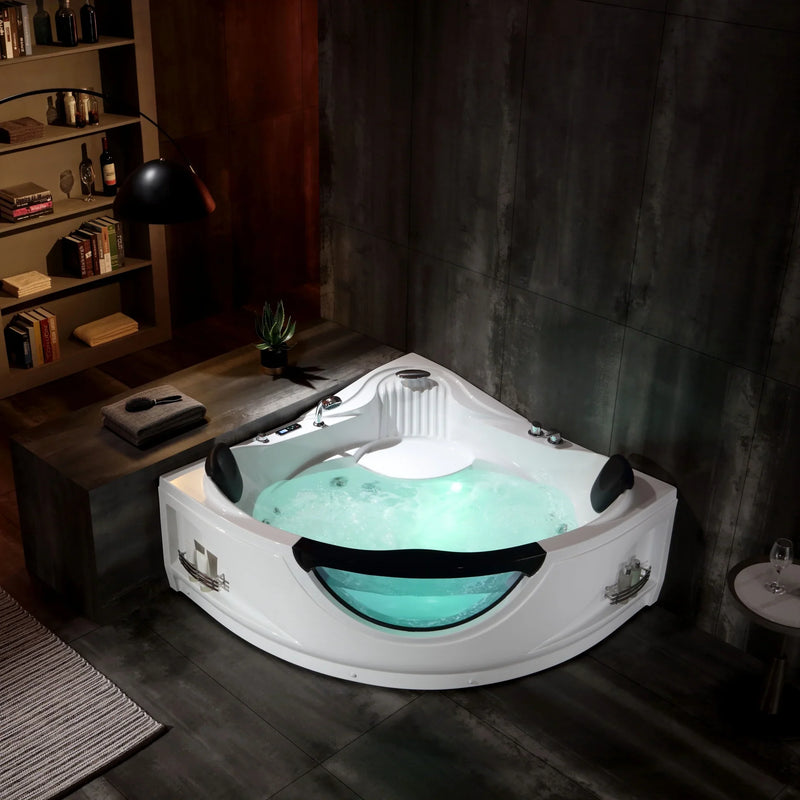 White corner jacuzzi tub filled with bubbling turquoise water, set against dark tiled bathroom wall with bookshelf visible in background.