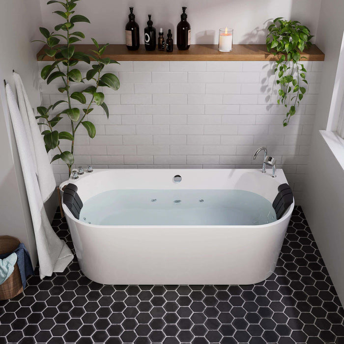 Modern bathroom with freestanding white tub, black hexagon floor tiles, subway wall tiles, and green plants creating a serene spa-like atmosphere.
