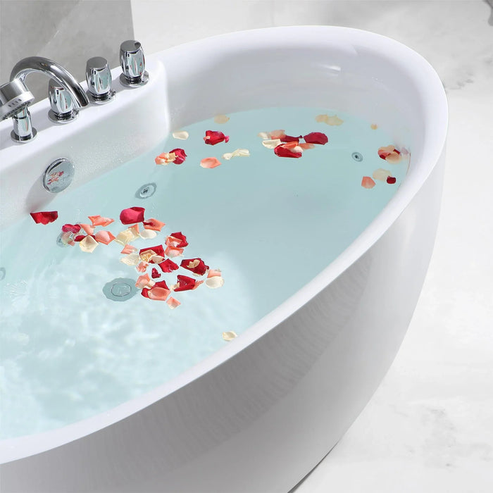 White bathtub filled with pale blue water and scattered red and pink rose petals, chrome faucet visible on left side.
