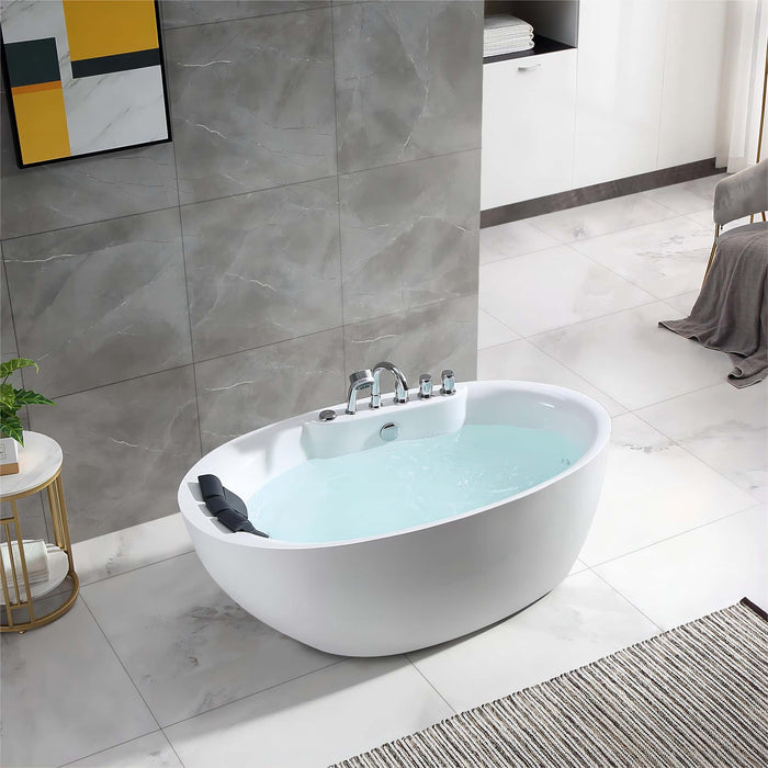 Modern white freestanding bathtub filled with water, set in a minimalist bathroom with gray marble tiles and a striped rug.