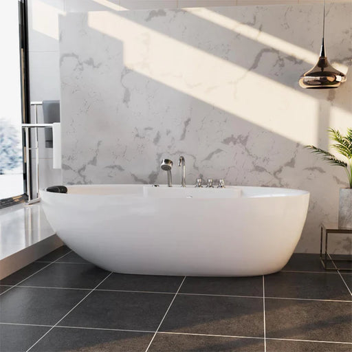 Modern white freestanding bathtub with marble wall, sleek metallic pendant light, and large window casting soft shadows.